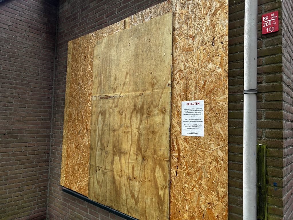 Houten platen voor de ramen bij een woning waar eerder twee keer een handgranaat is aangetroffen