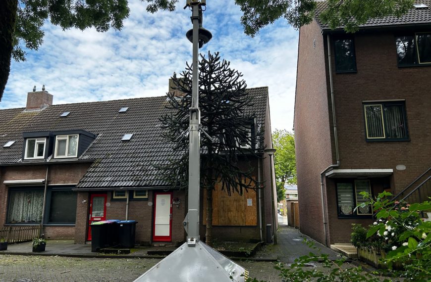 De gesloten woning, dichtgetimmerd en een mobiele camera voor de deur